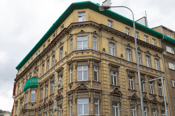 There is a large, impressive building characterized by its distinct green roof, and in front of it stands a tall street light illuminating the area