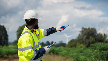 Service engineers checking system of windmill. Wind turbines generate electricity. Clean and Renewable energy concept.