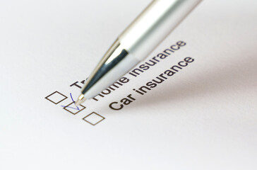 Fototapeta premium Checking off insurance options on a printed checklist with a pen