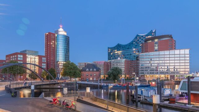Jan Fedder Promenade day to night transition timelapse hyperlapse in Hamburg, Germany, a vibrant waterfront area. Ships and boats on the Elbe River after sunset with famous buildings in background