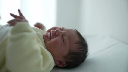 Newborn baby showing discomfort while nurse changes diaper during hospital routine. essential aspects of newborn care, highlighting the tender and careful handling required for infant hygiene