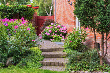 Garden, stairs and flowers for landscaping by home with spring growth, blooming season or ecology. Floral design, plants and eco friendly backyard for sustainability, gardening or natural environment