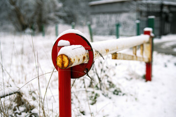 now-covered metal boom barrier stands solemnly, embodying a quiet pause in the winter landscape. Its reflective surface contrasts with the serene white blanket, suggesting both obstruction and safety