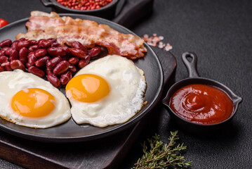 English breakfast with fried eggs, bacon, beans, tomatoes, spices and herbs
