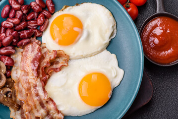 English breakfast with fried eggs, bacon, beans, tomatoes, spices and herbs
