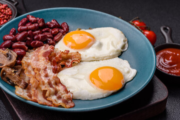 English breakfast with fried eggs, bacon, beans, tomatoes, spices and herbs