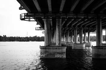 Nature meets industrialization, urban planning, piles that hold the bridge slab. Concrete slab, metal frame, bridge over the river.