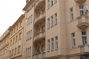 A long row of residential apartment buildings featuring balconies on the side of each unit, providing outdoor space for the residents