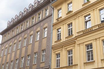 Fototapeta premium Next to a smaller structure, there stands a large building that features numerous windows, creating an interesting architectural contrast