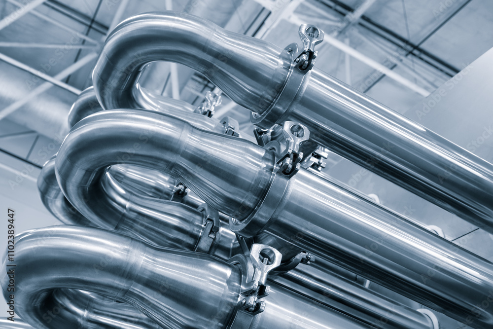 Poster dairy machine cooling radiator with a row of stainless steel metal pipes with silver trim. the pipes