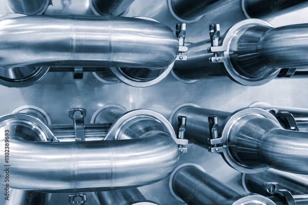 Poster dairy machine cooling radiator with a row of stainless steel metal pipes with silver trim. the pipes