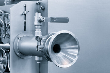 Dairy machine cooling radiator with a row of stainless steel metal pipes with silver trim. The pipes are connected to each other and appear to be part of a larger system