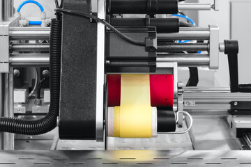 Fragment of the conveyor of sticking labeling machine. Abstract industrial background.