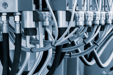 Close-up of precise industrial equipment with pneumatic components:  plastic tubes with connectors....