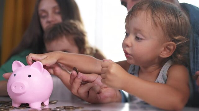 Family and group of babies put coins into piggy bank. the concept of the economy of a young family. family with children and piggy bank with money. a family with a baby and coins lifestyle in a bank.