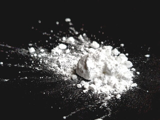 Splash of white powder on a black background. Copy space