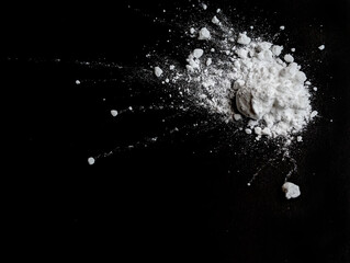 Splash of white powder on a black background. Copy space