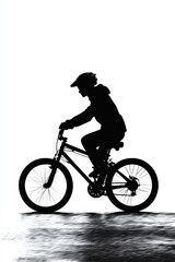 Obraz premium Silhouette of a male cyclist riding through a bright, monochromatic background, conveying a sense of adventure.