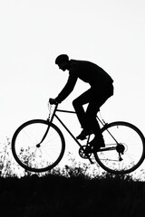 Silhouette of a male cyclist in motion, capturing an adventurous spirit against a stark white background.