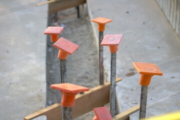 metal posts with orange coverings at construction site