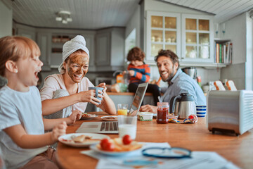 Happy family enjoying breakfast together in kitchen