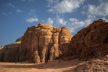 Sandstone Rock Formation in Sunny Desert in Southern Jordan. Wadi Rum Landscape with Rocky Mountain and Sandy Surface in the Afternoon.