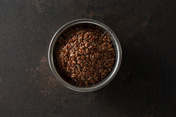 A top down view of a small metal bowl of flaxseed.