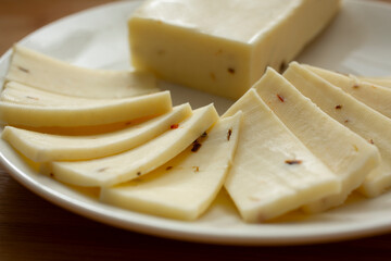 A closeup view of slices of pepper jack cheese.