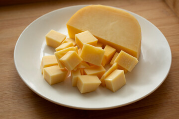 A view of a plate of cubes of gouda cheese.