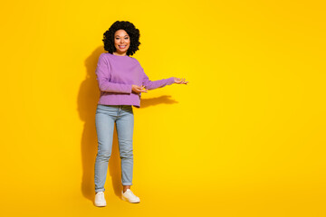 Full length photo of pretty young woman show empty space isolated on yellow color background