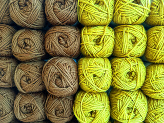 Close up view of balls of brown and lime green wool on display in a knitting shop..