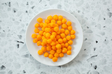 A top down view of some cheese balls on a plate.
