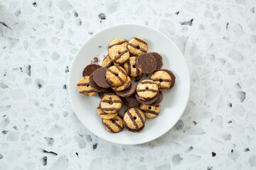 A top down view of a plate of mini fudge striped cookies.