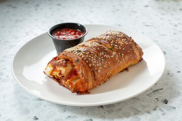 A view of a pepperoni and cheese stromboli.
