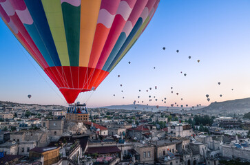 panorama sulle tipiche formazioni rocciose della cappadocia con le mongolfiere che le attraversano all'alba