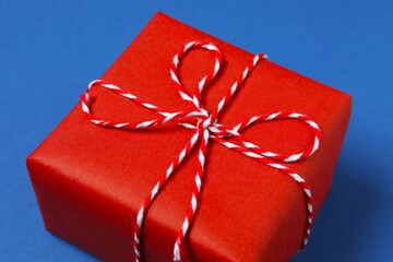 Beautiful gift box tied with bow on color background 