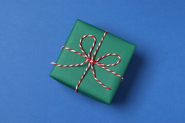 Beautiful gift box tied with bow on color background 