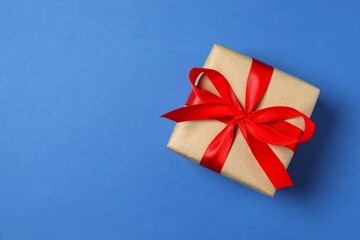 Beautiful gift box tied with bow on color background 