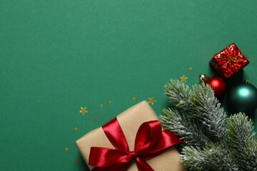 Beautiful gift box tied with bow and Christmas decorations on color background 