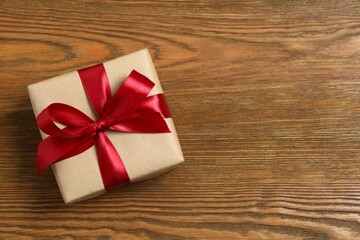 Beautiful gift box tied with bow on color background 