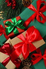 Beautiful gift boxes tied with bows and Christmas decorations on color background 