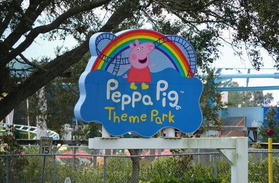 Winter Haven, Florida, U.S - Nov 12, 2024 - The Peppa Pig Theme Park sign, with its cartoon characters and rainbow, stands out against the surrounding landscape