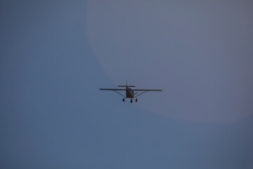A small plane flies over the Fervenza reservoir in Dumbria with a blue sky