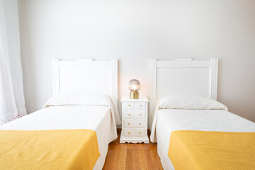 Bedroom with two small beds. Room with two 90cm beds made of white lacquered wood, white wall,...