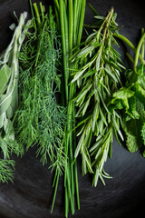 Fresh organic green herbs in an iron skillet with sage, rosemary, chives, dill, parsley. Heart healthy vegan vegetarian eating diet.