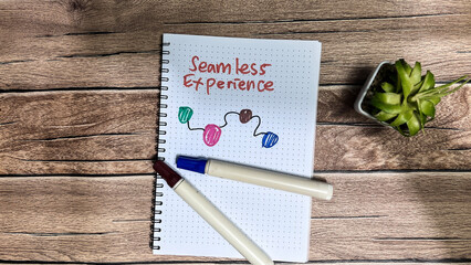 Concept of Seamless Experience write on book isolated on Wooden Table.