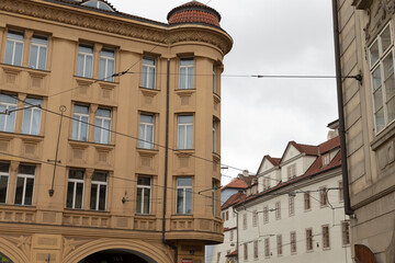 A vibrant and lively city scene showcases historic buildings lining the street beneath a cloudy sky