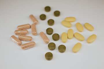 Multi-colored tablets of different shapes with different medical effects on a white background 
