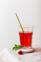 Raspberry drink in the glass on the light background.