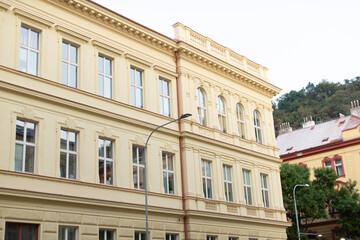 The facade of a historic building features an array of multiple windows, situated in an urban...